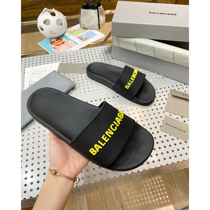 Ba*len*cia*ga pool slide sandal in black rubber with yellow 3d Ba*len*cia*ga logo